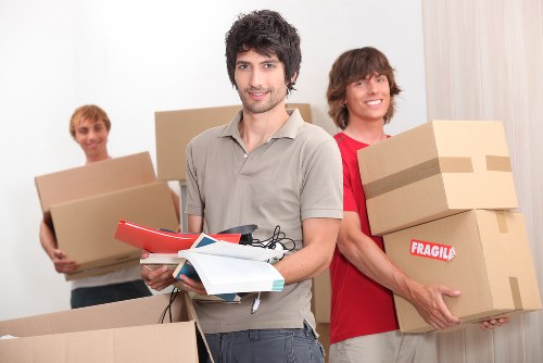 Professional movers handling furniture and packed boxes in a Wallington property